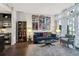 Living room of condo with sofa, armchair, glass coffee table, decorations on the wall, and a kitchenette at 111 N 12Th St # 1819, Tampa, FL 33602