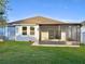 A view of the backyard showing a screened-in patio, well-kept lawn, and blue siding at 11566 Balintore Dr, Riverview, FL 33579