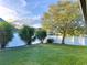 Lush backyard featuring a well-kept lawn, mature trees, and a white fence at 11566 Balintore Dr, Riverview, FL 33579