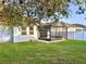 View of backyard with a screened in patio, a well maintained lawn and white privacy fence at 11566 Balintore Dr, Riverview, FL 33579