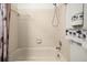 White tiled shower/tub combination with a handheld shower head and palm tree decor at 12308 Sun Vista W Ct # 45, Treasure Island, FL 33706