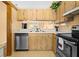Efficient kitchen design with stainless steel appliances, wood cabinets, and an open view to the living area at 12308 Sun Vista W Ct # 45, Treasure Island, FL 33706