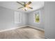 Bedroom features two windows, a ceiling fan, and wood-look flooring, offering a light and airy ambiance at 126 Highland St, Brooksville, FL 34601