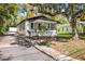 This home has a corner screened-in porch and is painted white with a black roof at 126 Highland St, Brooksville, FL 34601