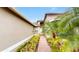 Inviting front entrance with a brick walkway and lush tropical landscaping at 15644 Aurora Lake Cir, Wimauma, FL 33598