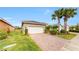 Attached two-car garage with a paved driveway and landscaped front yard, offering convenience and curb appeal at 15644 Aurora Lake Cir, Wimauma, FL 33598