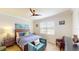 Comfortable main bedroom featuring a ceiling fan, soft blue bedding, and accent furniture at 15644 Aurora Lake Cir, Wimauma, FL 33598