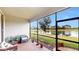 Screened porch with brick floor, plants, and outdoor seating with a view of the water at 15644 Aurora Lake Cir, Wimauma, FL 33598