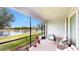 Screened porch with brick floor and comfortable seating with a view of the water at 15644 Aurora Lake Cir, Wimauma, FL 33598