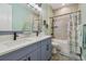 Stylish bathroom with double sinks, quartz countertops, tiled shower, and nautical decor at 17441 Savory Mist Cir, Bradenton, FL 34211