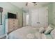 Charming bedroom with wood-look floors, soft green walls, ceiling fan, and white closet doors at 17441 Savory Mist Cir, Bradenton, FL 34211