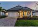 Beautiful single-story home with a covered front porch, two-car garage, and brick paved driveway at 17441 Savory Mist Cir, Bradenton, FL 34211