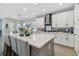 Open-concept kitchen with white cabinets, gray island, quartz countertops, and stainless steel appliances at 17441 Savory Mist Cir, Bradenton, FL 34211