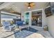 Outdoor living space with comfortable seating and view to backyard pool and lake at 17441 Savory Mist Cir, Bradenton, FL 34211