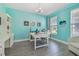 Bright office with built-in shelving, a modern desk, and calming teal walls at 17441 Savory Mist Cir, Bradenton, FL 34211