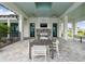 Inviting covered outdoor lounge featuring a stone fireplace, TV, and modern patio furniture for relaxing and entertaining at 17441 Savory Mist Cir, Bradenton, FL 34211