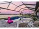 Screened-in pool area with a lake view and pink flamingo float at 17441 Savory Mist Cir, Bradenton, FL 34211