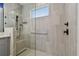 Modern bathroom shower featuring sleek gray tiling, glass enclosure, and matte black hardware fixtures at 17441 Savory Mist Cir, Bradenton, FL 34211