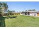 Spacious back yard with a well-maintained lawn, wooden fence and screened in lanai at 1803 Forest Dr, Oldsmar, FL 34677