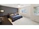 Spacious bedroom featuring a dark accent wall, a window and neutral carpeting at 1814 Cypress Trace Dr, Safety Harbor, FL 34695