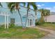 Charming condo with a bright blue exterior, complemented by lush landscaping at 209 Seahorse Se Dr # D, St Petersburg, FL 33705