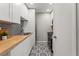 Galley kitchen featuring white cabinets, butcher block countertops, and stylish patterned floors at 209 Seahorse Se Dr # D, St Petersburg, FL 33705