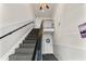 Carpeted staircase with black railing, leading to the upper level of the home at 209 Seahorse Se Dr # D, St Petersburg, FL 33705