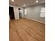 A view into a bedroom featuring wood-look floors, two windows, and a view into an ensuite bathroom at 2602 Surrey Dr, Palm Harbor, FL 34684