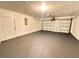 A spacious garage with a gray floor and white walls and door at 2602 Surrey Dr, Palm Harbor, FL 34684