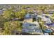 Aerial view showcases home, fenced backyard, and pool, nestled among trees and other residences at 2833 56Th N Ln, St Petersburg, FL 33710