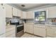 Bright kitchen with white cabinets, stainless steel appliances, and a backyard view from the window at 2833 56Th N Ln, St Petersburg, FL 33710