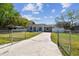 Wide concrete driveway leading to a cozy home with stone accents and a manicured lawn at 3010 W Van Buren Dr, Tampa, FL 33611