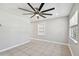 Bright living room features a modern ceiling fan, neutral walls, and tile flooring at 3010 W Van Buren Dr, Tampa, FL 33611