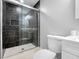 Modern bathroom with a black tiled shower, glass door, and a white vanity, combining style and functionality at 3104 Bay St, Sarasota, FL 34237