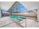 Screened-in pool area featuring a geometric-shaped pool, surrounded by a spacious patio, perfect for relaxation at 3104 Bay St, Sarasota, FL 34237