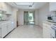 Eat-in kitchen features white cabinets, a skylight, and access to the sunroom at 3416 Annette Ct # 71, Clearwater, FL 33761