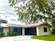 Charming single-story home with a metal roof, dark garage door, and stone facade detail at 3608 Oak Bark Ln, Brandon, FL 33511