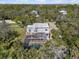 Aerial view of home featuring in ground pool with an enclosed screened in patio surrounded by green grass and trees at 375 Wellington Ave, Oldsmar, FL 34677