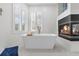 Bright bathroom featuring soaker tub, gas fireplace, and plantation shutters at 375 Wellington Ave, Oldsmar, FL 34677
