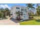 Stunning modern two-story home featuring a clean white facade, landscaped yard, and tropical palm trees at 375 Wellington Ave, Oldsmar, FL 34677