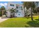 Modern white home with a well-maintained lawn, palm trees and updated blue stair railing at 375 Wellington Ave, Oldsmar, FL 34677