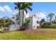 Modern home with white exterior, lush landscaping, and screened-in pool area, set on a green lawn at 375 Wellington Ave, Oldsmar, FL 34677