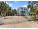 View of the property featuring an imposing white exterior gate and a gravel driveway at 375 Wellington Ave, Oldsmar, FL 34677