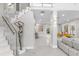 Elegant home foyer featuring a glass-railed staircase, marble floors, and a decorative sculpture at 375 Wellington Ave, Oldsmar, FL 34677