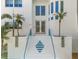 Beautiful modern home with bright, white exterior, stairs with vibrant, blue railings, and mature palms at 375 Wellington Ave, Oldsmar, FL 34677