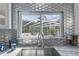Close-up of a sink with a window view and unique backsplash in a modern kitchen design at 375 Wellington Ave, Oldsmar, FL 34677