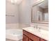 Relaxing bathroom with a soaking tub, vanity with sink, and large framed mirror at 418 S Habana Ave, Tampa, FL 33609