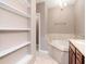 Relaxing bathroom with a soaking tub, vanity with sink, and a shelved wall space at 418 S Habana Ave, Tampa, FL 33609