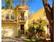 Charming yellow townhome featuring a red tile roof, private balcony, and well-manicured landscaping at 418 S Habana Ave, Tampa, FL 33609