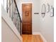 Hallway view featuring hardwood floors, a staircase with a metal railing, and neutral paint at 418 S Habana Ave, Tampa, FL 33609